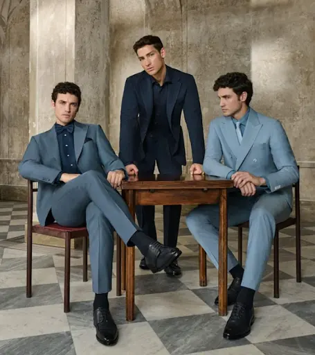 Three men pairing blue suits with navy shirts, a bow tie and a knitted tie in tonal colour combinations
