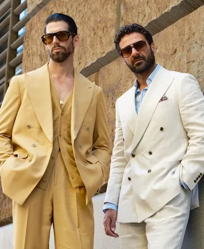 Two men in double-breasted summer suits, the cream linen jacket finished with a patterned silk pocket square
