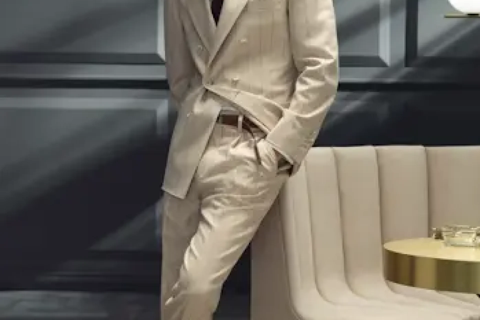 Man wearing a cream pinstripe double-breasted custom suit with a white shirt, burgundy tie, and dark derby shoes